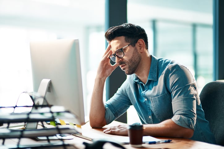 Man aan het denken achter zijn computer