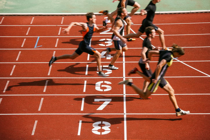 Mannen rennen op atletiek baan