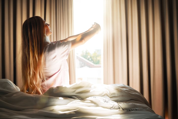 Vrouw ontwaakt in de ochtend zon