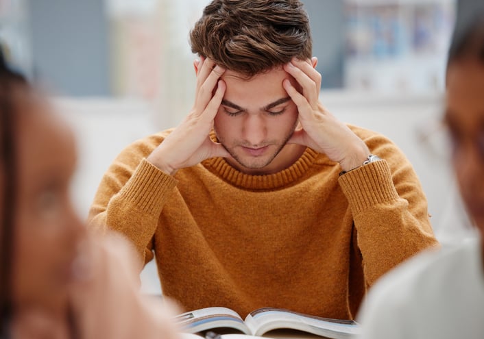 man-zit-met-handen-in-het-haar