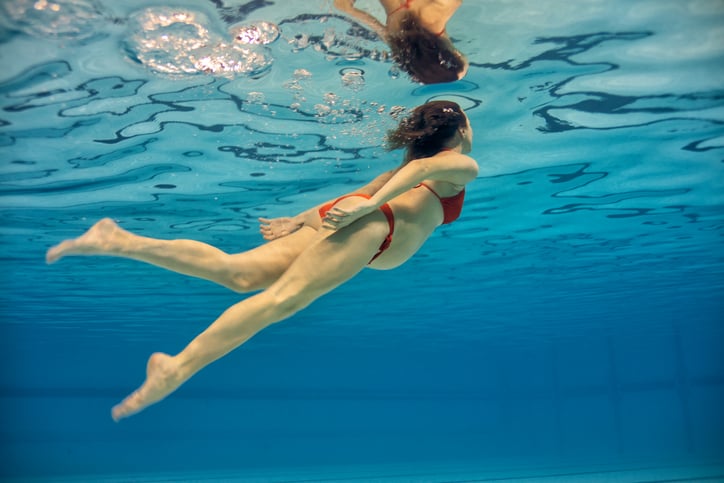 zwangere zwemmende vrouw onder water