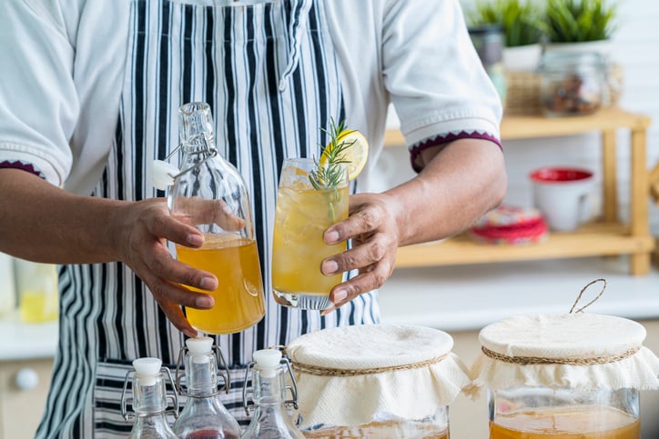 Persoon houd een fles en een glas in zijn hand