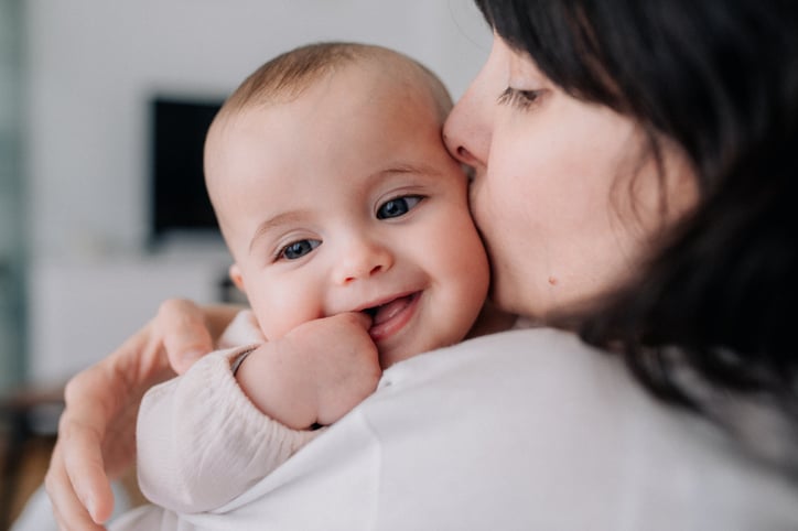 Vrouw geeft baby een kus