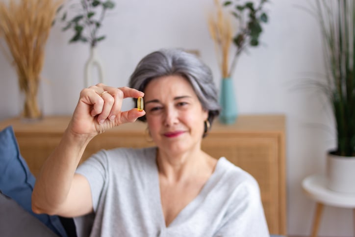 Vrouw houd pil vast en kijkt ernaar